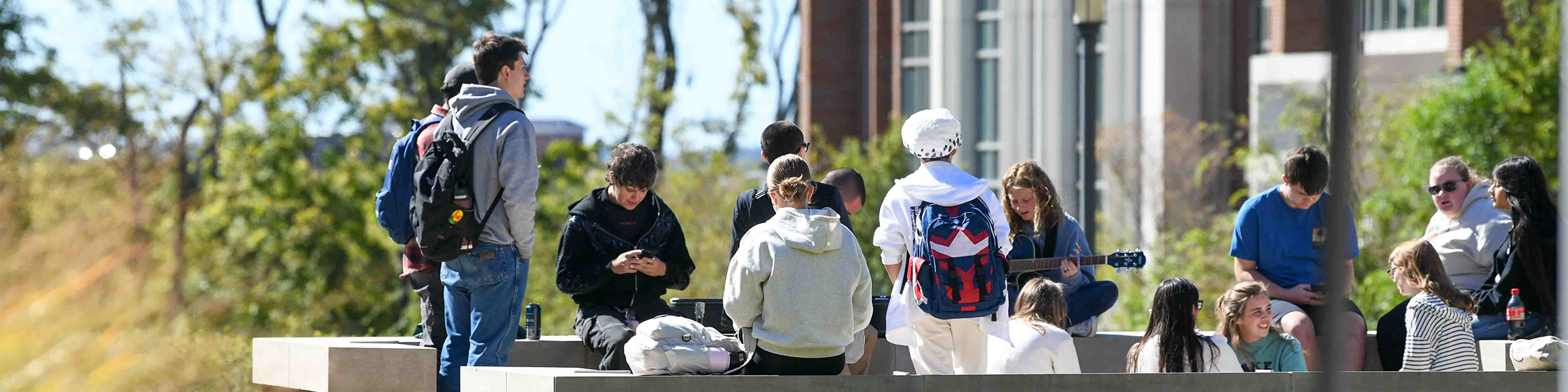 A group of students sitting and standing outdoors on the Williamson campus.