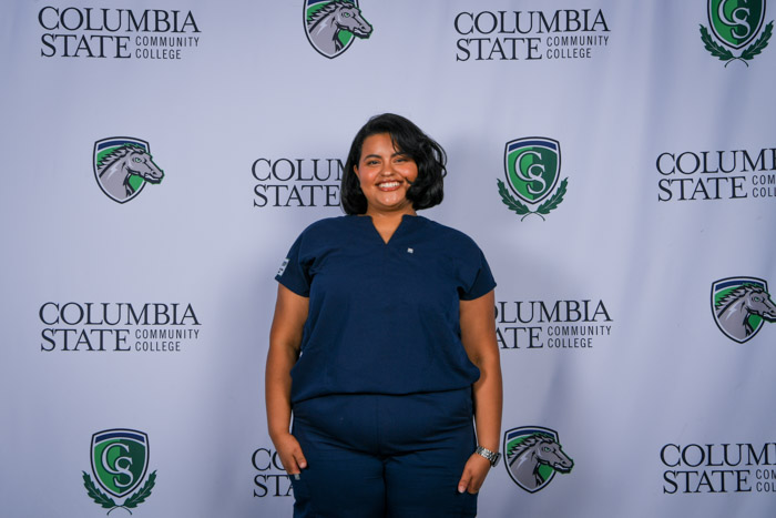 A person poses in front of a white background. 