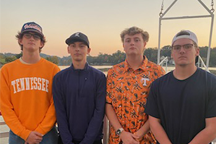 Four male student with sunset in the background